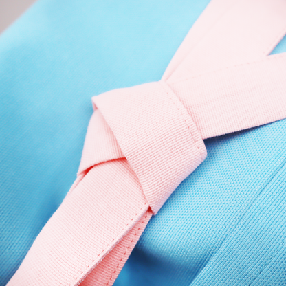 Close-up of the pink strap tied on a personalized blue apron