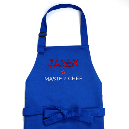 Personalized royal blue apron with a tied bow, embroidered "Jarek ★ Master Chef"