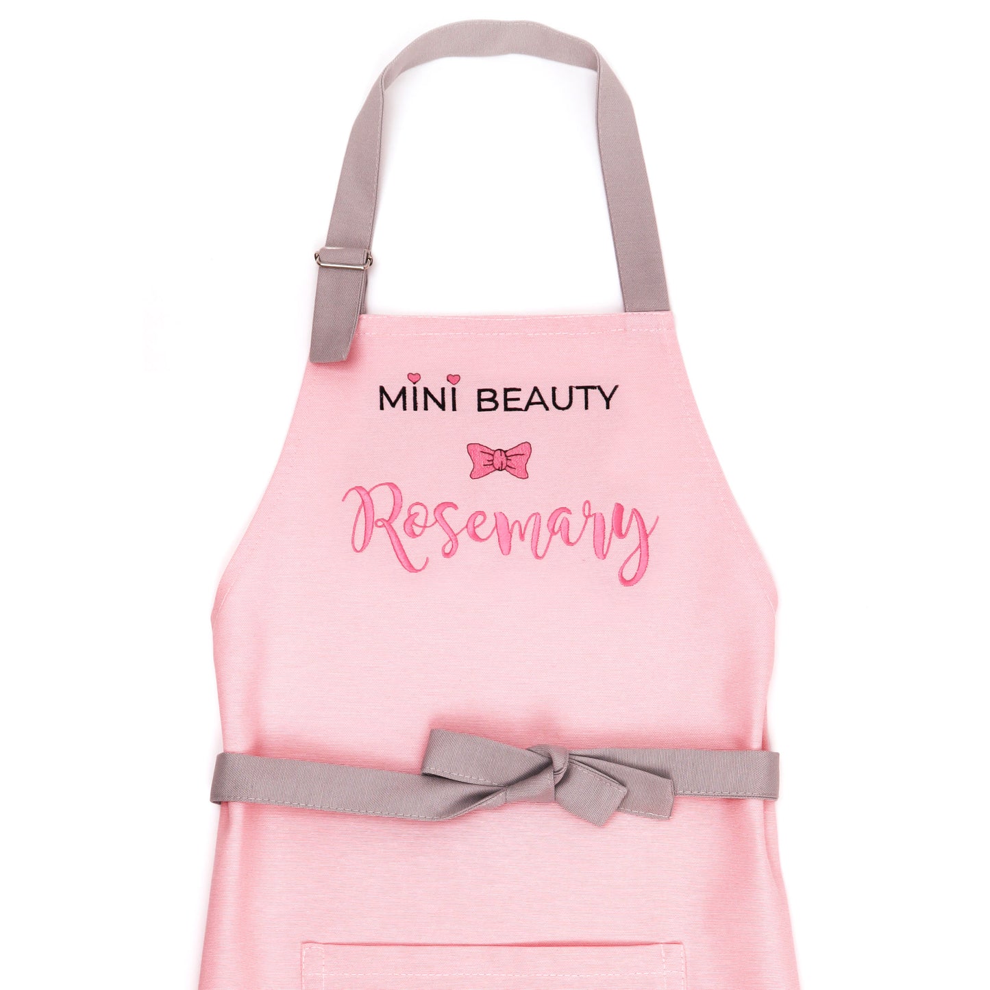 Personalized pink Mini Beauty apron for girls with embroidered name and bow — handmade in Minnesota