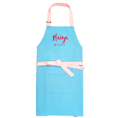 Personalized blue apron on a white background, tied bow, embroidered "Maiya ♥ Chef"