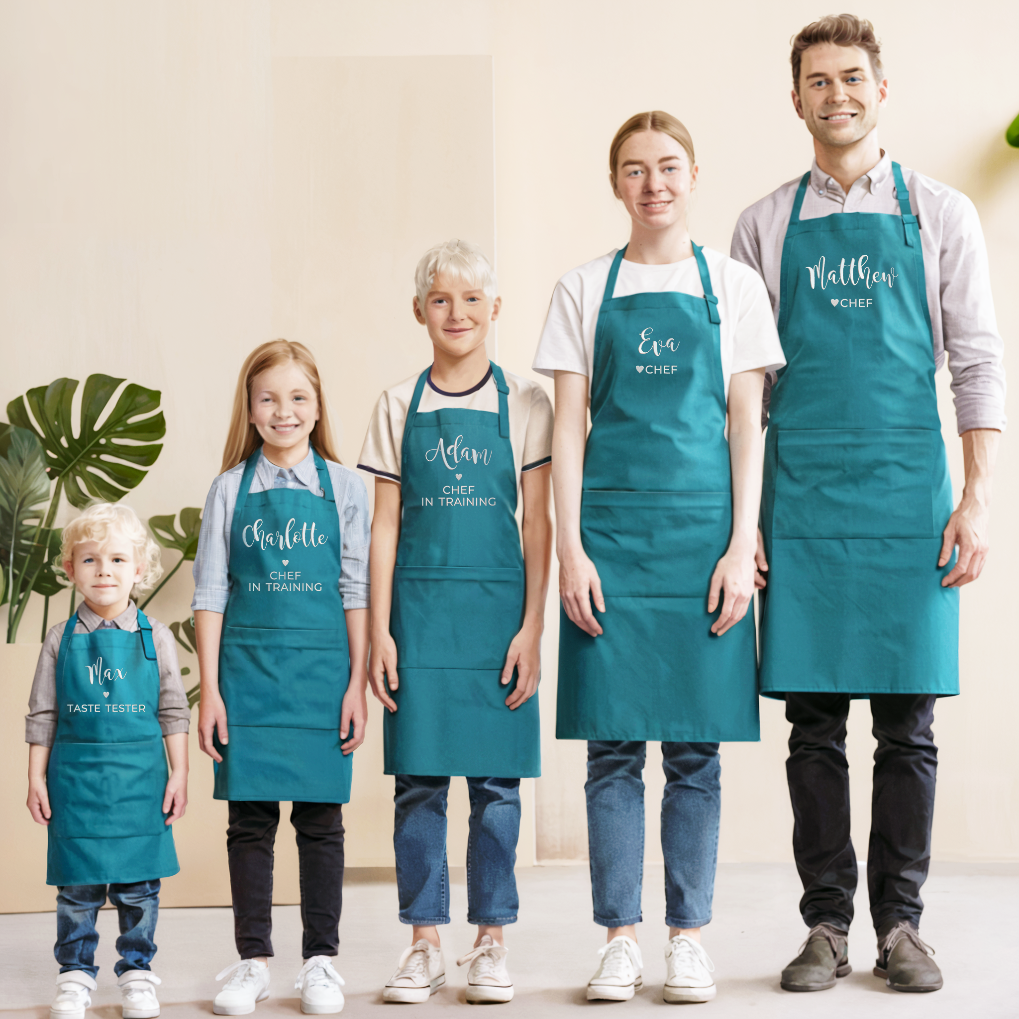 Family wearing teal aprons with names embroidered, toddler, little kid, big kid, teen, adult