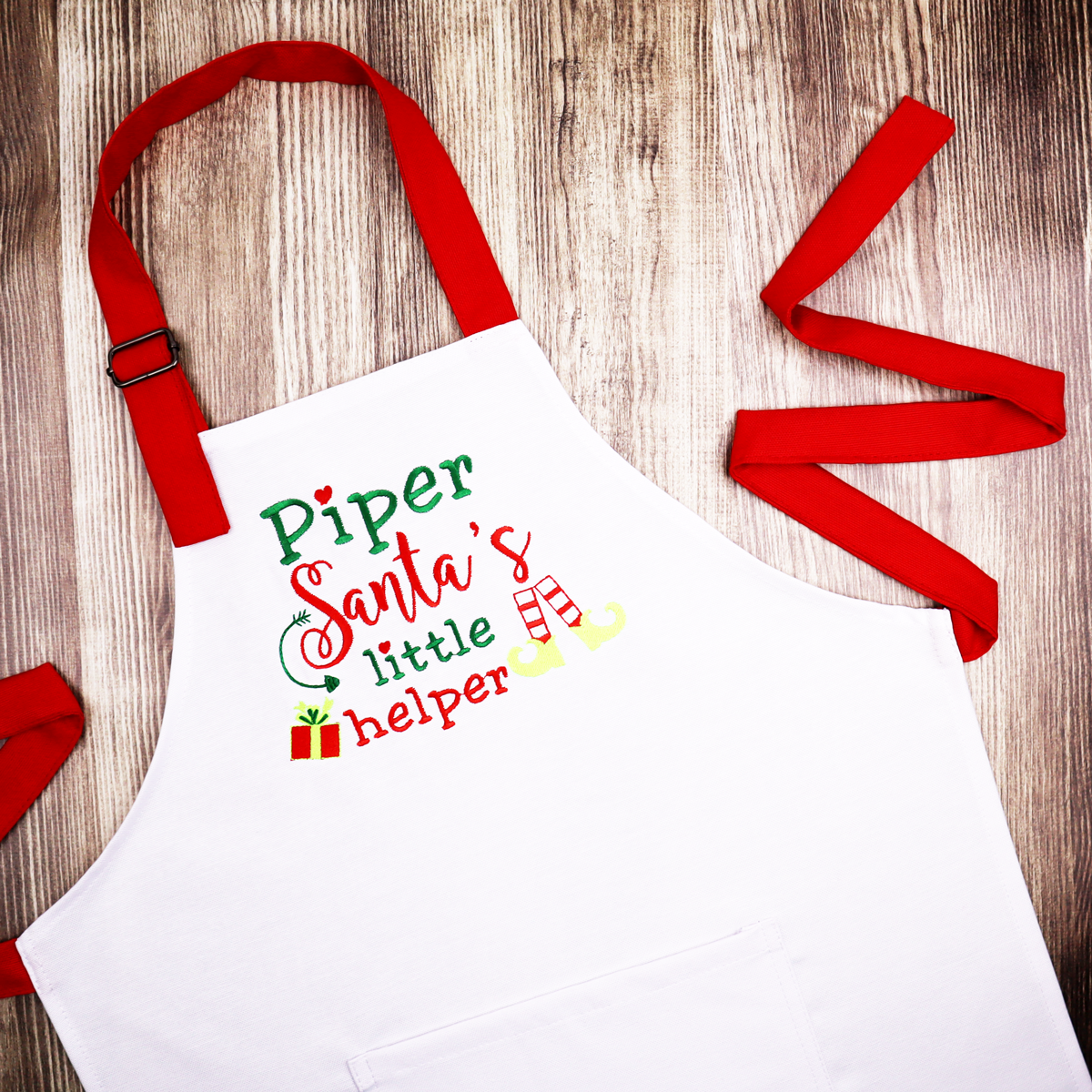 White Christmas apron with pocket, red straps and  personalized Santa's little helper embroidery 