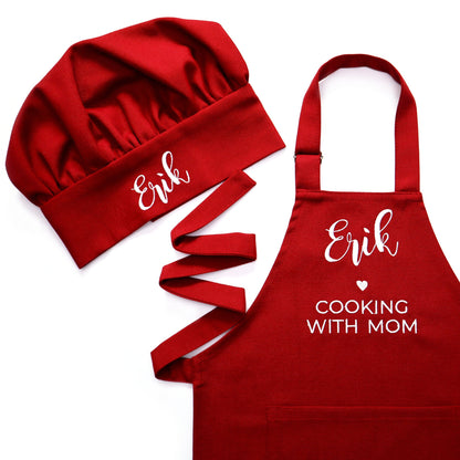 Personalized dark red apron and chef hat set on a white background, embroidered with the name "Erik" and "Cooking with Mom" in white script